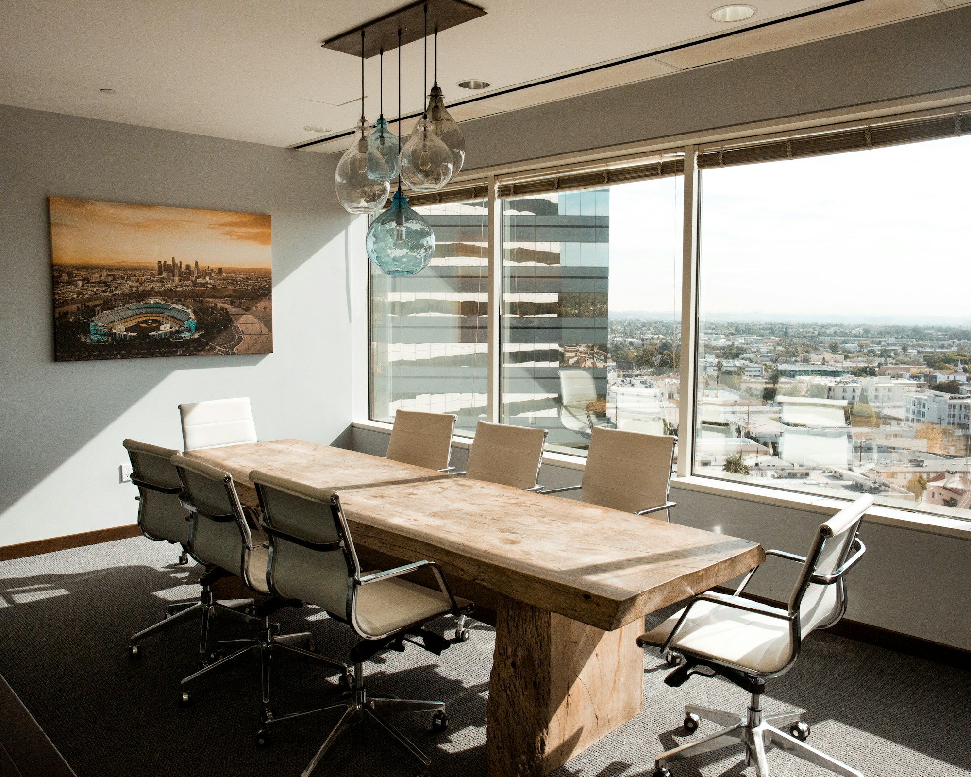 Beige wooden conference table in a daylit boardroom